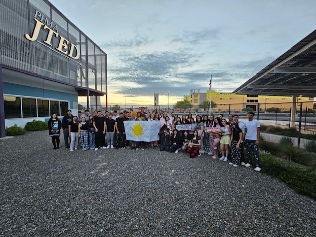 Seniors pose with a banner for Senior Sunrise