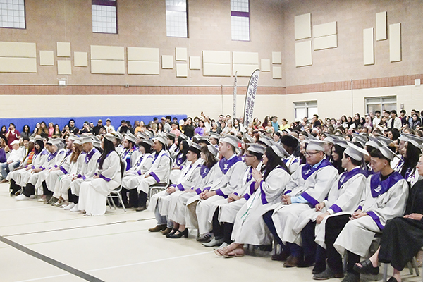 Graduates sit in the gym during the ceremony