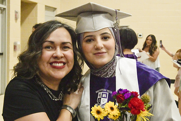 A graduate poses for a photo with her mom after the ceremony