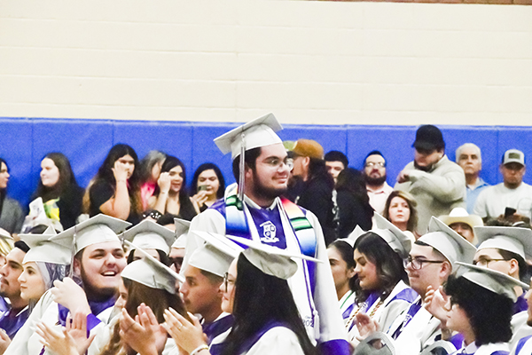 A graduate stands up proudly during the ceremony