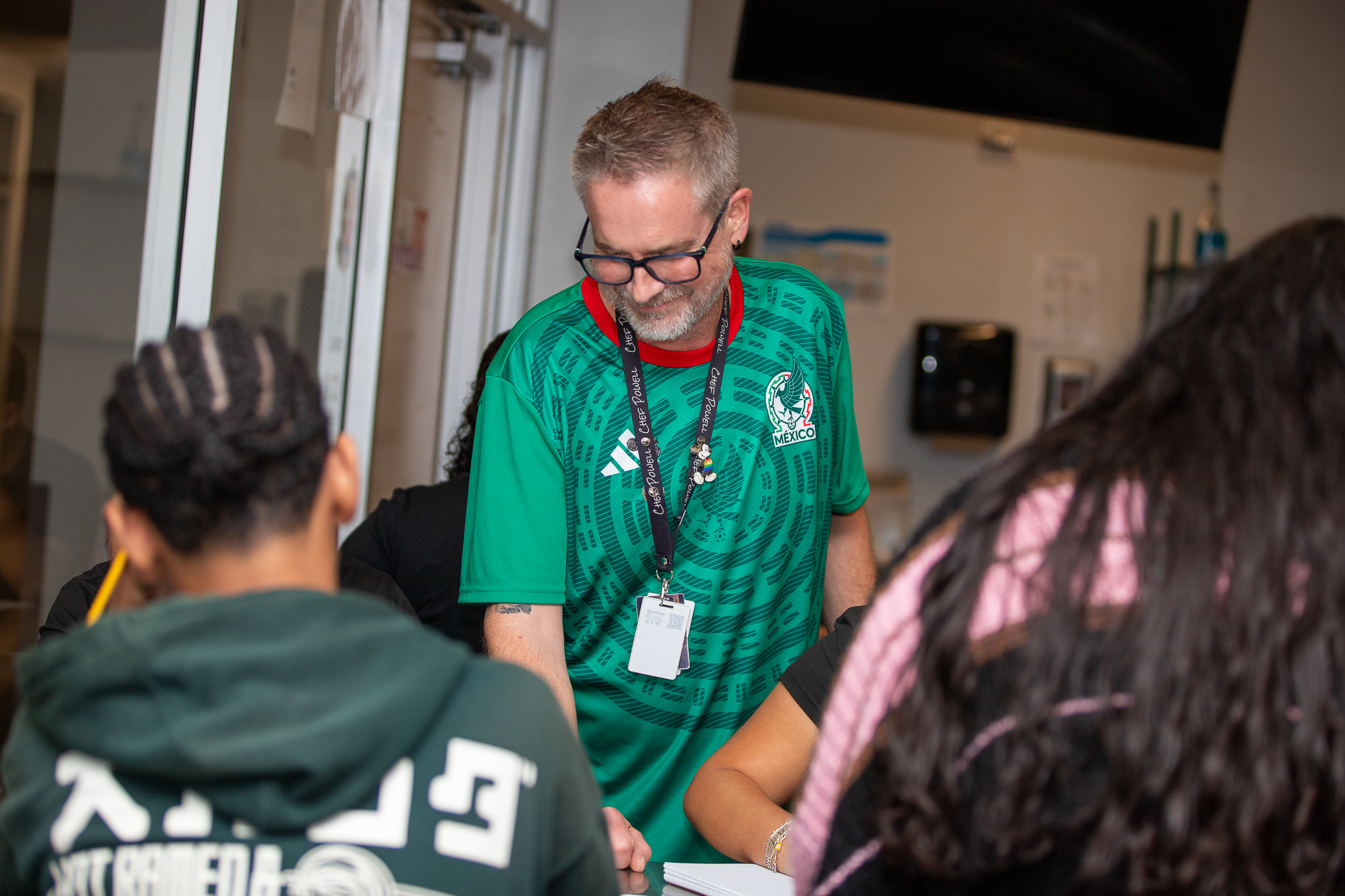 A teacher smiles as he works with his students